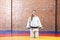 Beautiful athletic young karate woman in white kimono in fighting stance close up black belt and looking at camera. Japanese mart