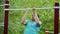 Beautiful athletic young man pulls up on horizontal bar for training on sports yard for workout outdoors