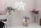 Beautiful, atmospheric interior of room, hall. Decorative flowers on stands, a vase, bust, table and feather decoration will