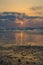 Beautiful atmospheric sunset at beach with reflections and plack pebbles, coast at Sidi Ifni, Morocco, North Africa