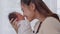 Beautiful Attractive Asian mom holding baby newborn in hand and kissing on baby nose sweet lovely.Happy mother and infant baby