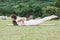 Beautiful Attractive Asian woman practice yoga Locust or Shalabhasana pose with yoga meditation relax and refresh health on Meadow