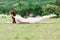 Beautiful Attractive Asian woman practice yoga Locust or Shalabhasana pose with yoga meditation relax and refresh health on Meadow