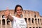 Beautiful attractive brunette tourist girl close to majestic Colosseum in Rome, Italy