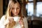 Beautiful attractive business woman in a white blouse drinks cofee in the cafe