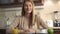 Beautiful attractive casual young woman sitting in her kitchen smiling. Happy and relaxed at home.