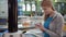 Beautiful attractive woman in airport terminal. Standing near charging stand pluging in smartphone