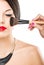 Beautiful attractive woman with half face, luxury makeup brush of his face