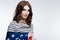 Beautiful auburn-haired woman posing wrapped in US flag