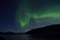 Beautiful aurora borealis dancing over mountain and fjord landscape on late autumn