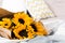Beautiful authentic yellow sunflowers bouquet with craft paper in bed