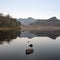 Beautiful Autumn Fall colorful sunrise over Blea Tarn in the Lake District with High Raise and The Langdales in the distance