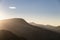 Beautiful Autumn Fall landscape image of sun beams lighting up small area of mountain side in Lake District whilst rest of area is