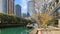 a beautiful autumn landscape along the Ogden Slip waterway with boats docked on the green water, autumn colored trees