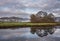 Beautiful Autumn landscape image of River Brathay in Lake District lookng towards Langdale Pikes with fog across river and vibrant