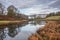 Beautiful Autumn landscape image of River Brathay in Lake District lookng towards Langdale Pikes with fog across river and vibrant