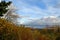 Beautiful autumn landscape. View on the river and cloudy sky with colorful bushes on the foreground