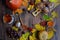 Beautiful autumn layout of colorful leaves, pumpkins, grapes, pumpkin muffins, sea buckthorn tea on a dark wooden background