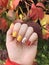 Beautiful autumn manicure design on well-groomed female nails. Soft square shape. Fall leaves
