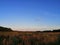 A beautiful autumn meadow illuminated by the rays of sunset. High blue sky.