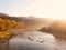 Beautiful autumn morning in picturesque Carpathians. Soft sunlight awakens nature from sleep. Light mist extends over the river