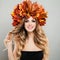 Beautiful autumn portrait of pretty cheerful woman in autumn leaves crown. Makeup, blonde curly hair