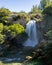 Beautiful autumn scene where a huge waterfall of water falls into the void of a canyon on a sunny autumn day, creating a relaxing