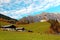 Beautiful autumn scenery of St. Nikolaus Church high on the hilltop with rugged Hochkoenig Mountain range in background