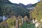 Beautiful autumnal landscape in the mountain forest at sunset with village pass along the rocks.