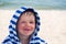 Beautiful baby with blue eyes on the sea background smiling, sweet and gentle. Cute child with atopic dermatitis