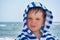 Beautiful baby with blue eyes on the sea background smiling, sweet and gentle. Cute child with atopic dermatitis