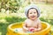 beautiful baby girl in Cotton Panama Cap bathes in yellow Inflatable Swimming Paddling Pool