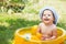 beautiful baby girl in Cotton Panama Cap bathes in yellow Inflatable Swimming Paddling Pool