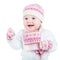 Beautiful baby girl in a knitted sweater, hat and scarf