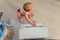 beautiful baby girl playing toy piano in light room. Authentic image