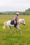 Beautiful baby girl on a white horse galloping