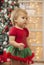 Beautiful baby in a New Year`s suit. Christmas decorations
