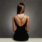 Beautiful back of young woman in a black dress. luxury. beauty brunette sitting girl Girl with a necklace on her back