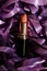 Beautiful background with matte lipstick and violet satin ribbons. Beauty professional make up products, female festive present.