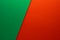 Beautiful background of two unequal parts of green and red paper. Sheets of blank green and red paper with fine texture devided