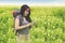 Beautiful backpacker with smartphone in flower field