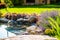 Beautiful backyard landscape design. View of colorful trees and decorative trimmed bushes rocks