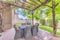 Beautiful backyard patio of a home with table and chairs under a wooden pergola