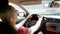 Beautiful bald woman in sun-protection glasses driving a car in traffic.