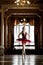 Beautiful ballerina dancing in a luxurious hall in a red dress