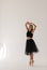 Beautiful ballerina dancing at studio in black dress, have training.