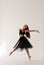 Beautiful ballerina dancing at studio in black dress, have training.