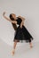 Beautiful ballerina dancing at studio in black dress, have training.