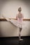 Beautiful ballerina warming up with the barre