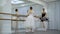 Beautiful ballerinas are practiced near barre in ballet studio.